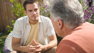 To mænd sidder overfor hinanden og taler sammen.