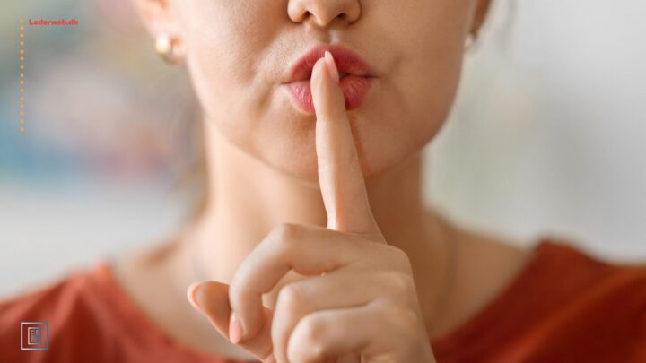 Kvinde, der holder pegefingeren op foran munden som for at tysse.