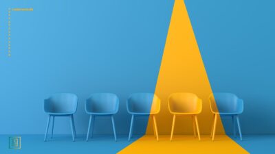 Fem stole i et blå rum, hvor et trekantet område er gult, og en enkelt stol er gul, mens resten er blå.