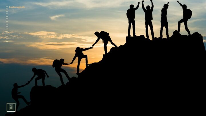 Siluetter af mennesker, der rækker ud efter hinanden og hjælper hinanden op ad et bjerg i skumringstimen.