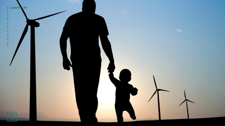 Mørk siloet af far, der går med lille barn i hånden blandt vindmøller i modlys.