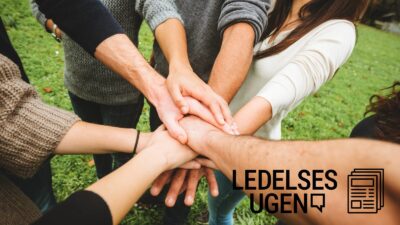 Syv personer rækker hånden frem, så de syv hænder mødes.